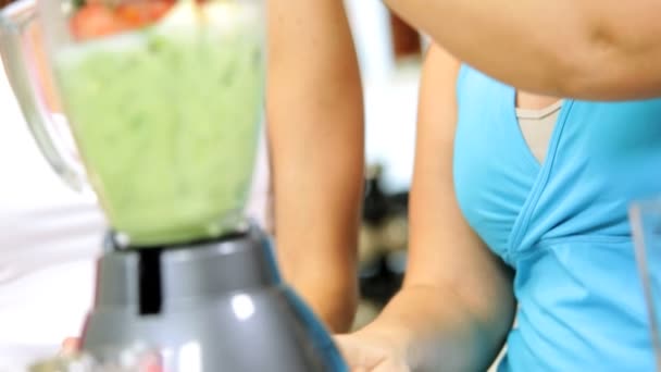 Caucásico gimnasio niñas y madre haciendo saludable vegetal smoothie — Vídeos de Stock
