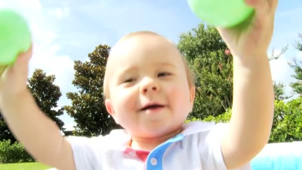 Bébé garçon s'amuser avec des parents jouant dans une piscine à balles multicolore — Video