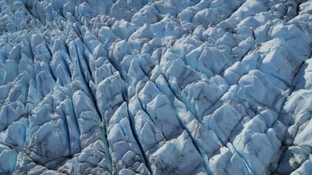 Luchtfoto van blauw ijs gletsjer voortdurend in beweging met spelonken bang met moraine, noordelijk halfrond Arctische regio geschoten op het rode epos — Stockvideo