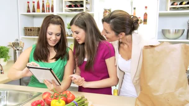 Mulher de negócios e meninas adolescentes usando a tecnologia tablet sem fio em casa cozinha — Vídeo de Stock