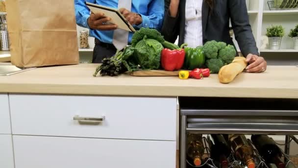 Деловая пара на кухне готовится с планшетом — стоковое видео