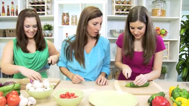 Mãe assistindo como filhas adolescentes cortando vegetais orgânicos frescos — Vídeo de Stock