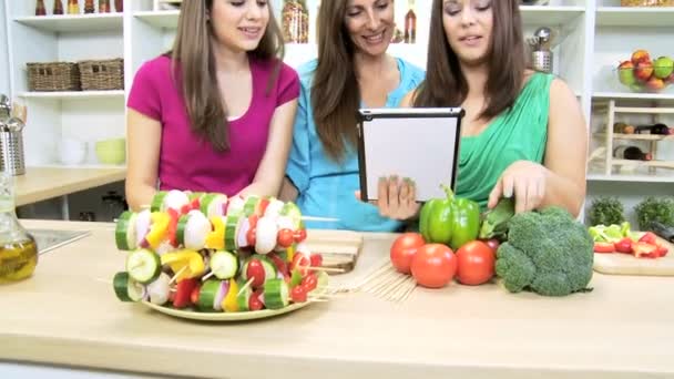 Brunette girl at home kitchen with  mother and sister using wireless tablet — Stock Video