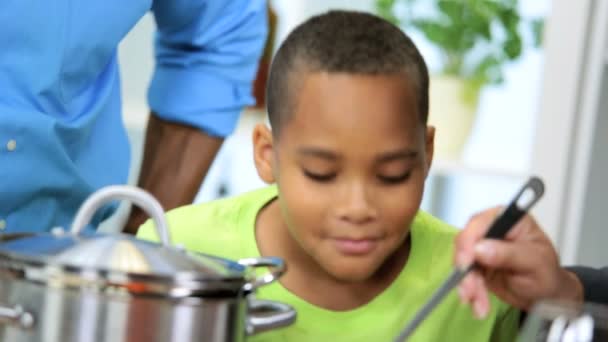 Etnische ouders jonge zoon genieten van gezond thuis koken samen — Stockvideo