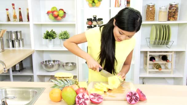 Vrouw in kitchen voorbereiding van ananas — Stockvideo