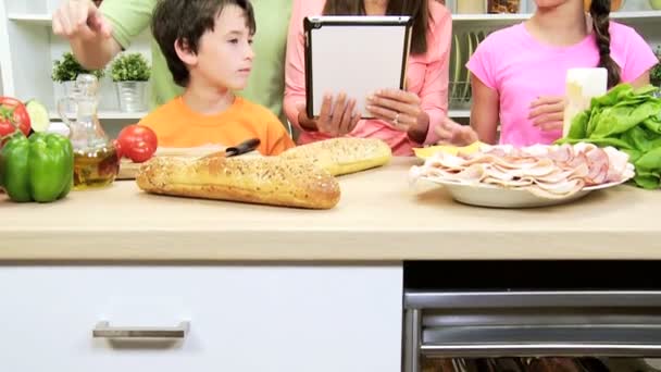 Familie bereitet Mittagessen mit Tablet zu — Stockvideo