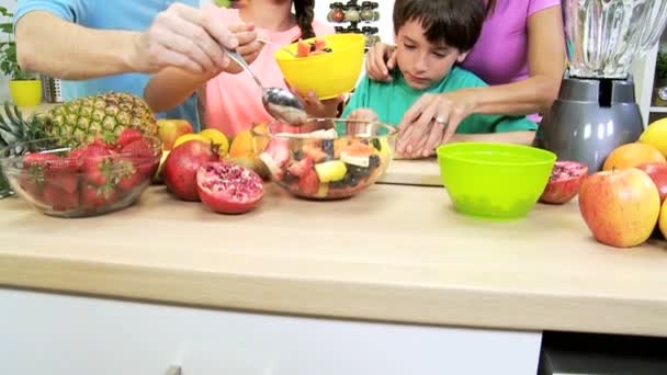 Família em conjunto preparando salada de frutas — Vídeo de Stock