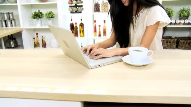 Vrouw bij keuken met behulp van laptop — Stockvideo