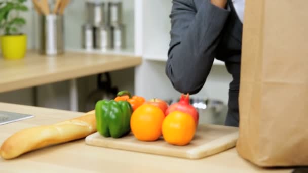 Zakenvrouw in kitchen tas uitpakken — Stockvideo