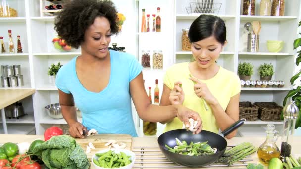 Подружки на кухні готують овочі — стокове відео