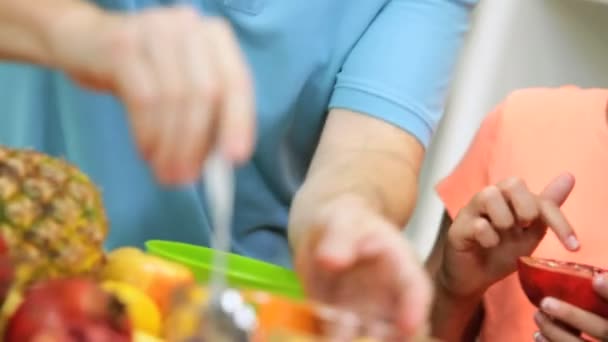 Pais e crianças preparando salada — Vídeo de Stock