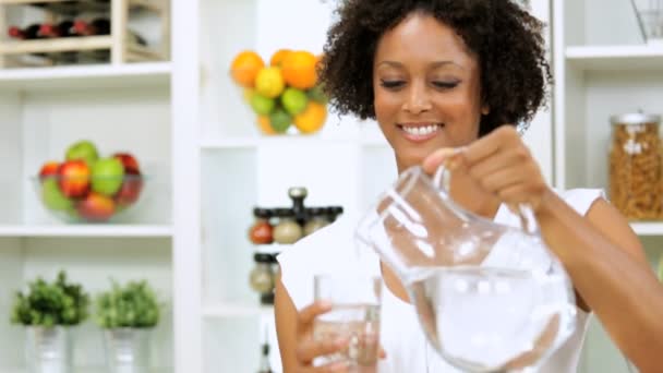 Девушка пьет воду на кухне — стоковое видео