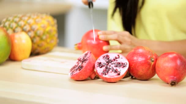 Female at kitchen slicing pomegranate — Stock Video
