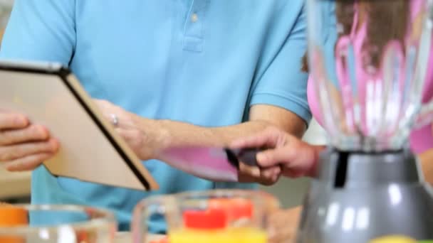 Pareja preparando fruta usando tableta — Vídeo de stock