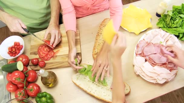 Föräldrar och barn fyller baguetter — Stockvideo