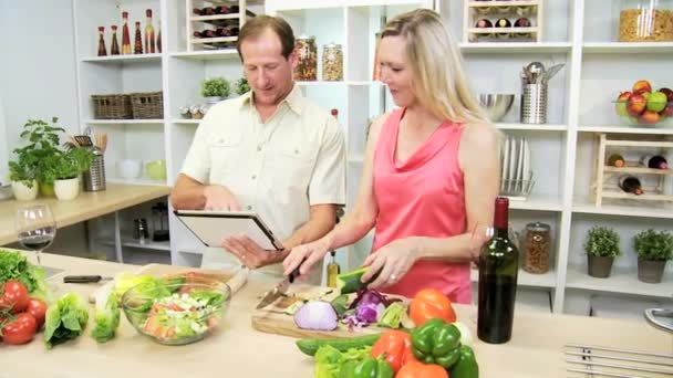 Casal preparando salada usando comprimido — Vídeo de Stock