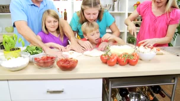 Familie bereitet gemeinsam hausgemachte Pizza zu — Stockvideo