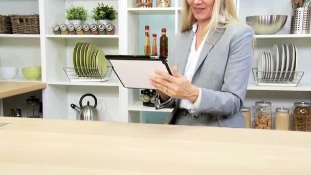 Бизнесвумен с помощью планшета на кухне — стоковое видео