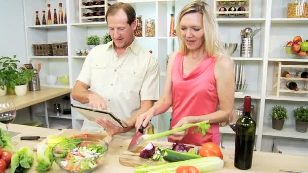 Casal preparando salada usando comprimido — Vídeo de Stock