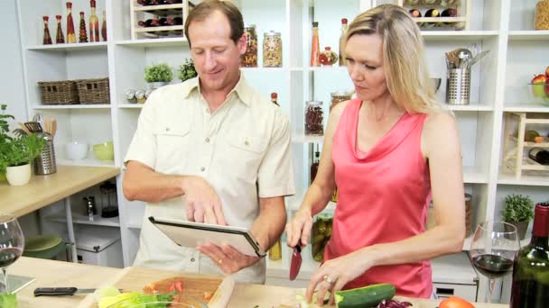 Пара готує салат за допомогою планшета — стокове відео