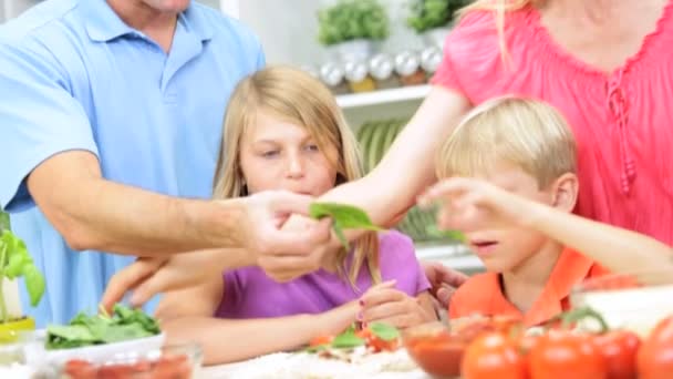 Pais ajudando as crianças a preparar alimentos — Vídeo de Stock