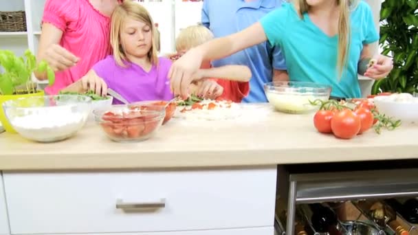 Parents et enfants préparant une pizza — Video