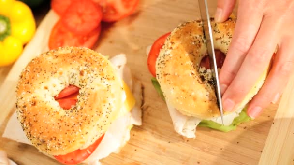 Female slicing fresh granary bagels — Stock Video