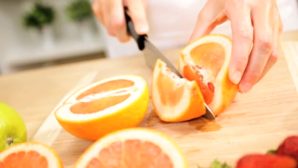 Κοντινό πλάνο γυναικεία χέρια σε φέτες φρέσκα βιολογικά πορτοκάλια — Αρχείο Βίντεο