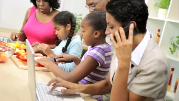 Empresaria trabajando y hablando por teléfono móvil cuando la familia cocina en la cocina — Vídeos de Stock