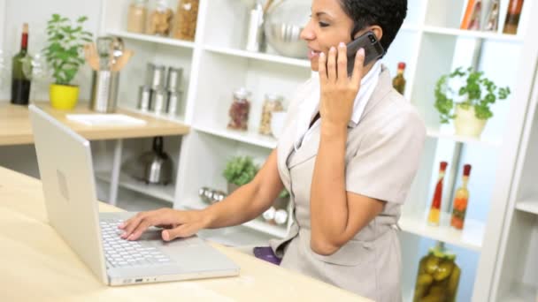 Mujer de negocios hablando en el teléfono móvil y trabajando en el ordenador portátil — Vídeos de Stock