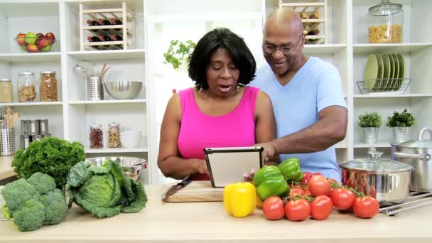 Pareja en la cocina preparando con la tableta — Vídeos de Stock