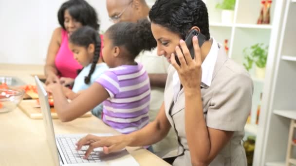 Affärskvinna, arbete och talar i en mobiltelefon när familjen kockar i köket — Stockvideo