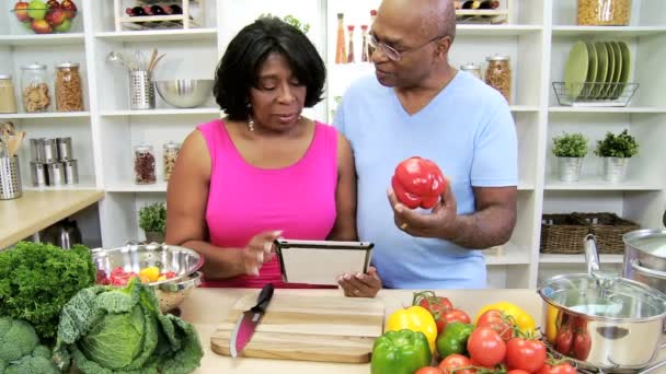 Pareja en la cocina preparando con la tableta — Vídeos de Stock