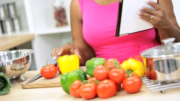 Женщина на кухне с помощью планшета — стоковое видео