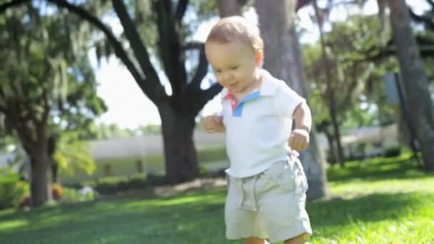 Niño caminando descalzo sobre la hierba — Vídeos de Stock