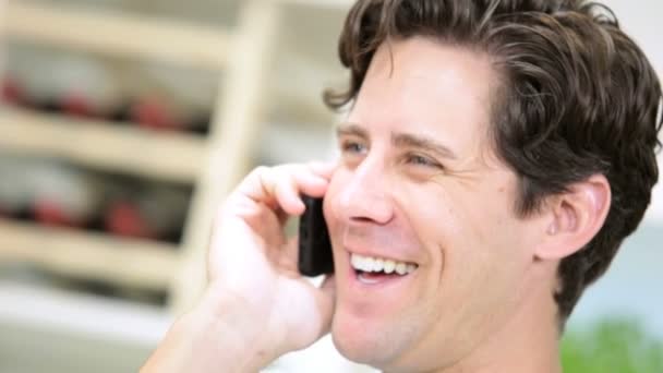 Мужчина разговаривает по смартфону на кухне — стоковое видео