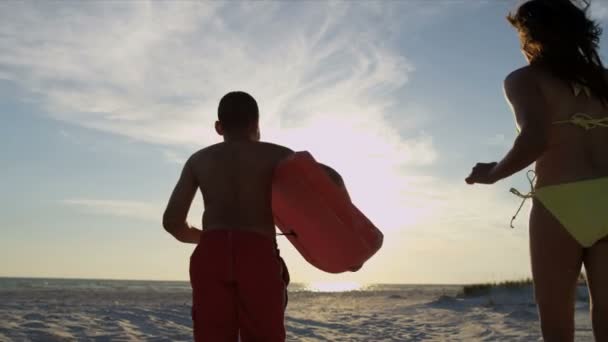 Family running across beach — Stock Video