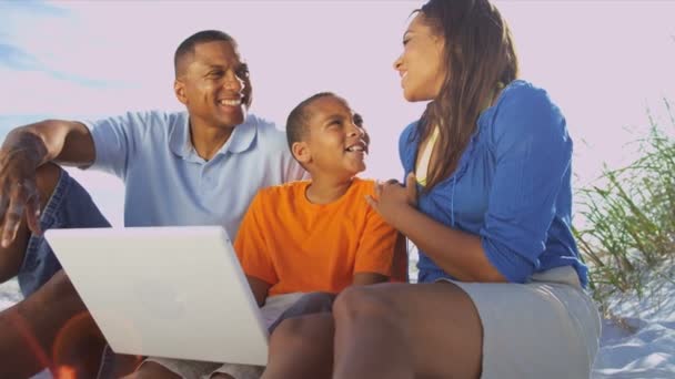 Familia en la playa usando portátil — Vídeos de Stock