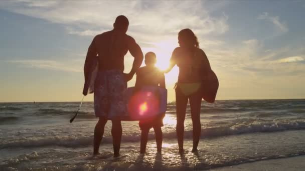 Familie kijken naar zonsondergang op het strand — Stockvideo