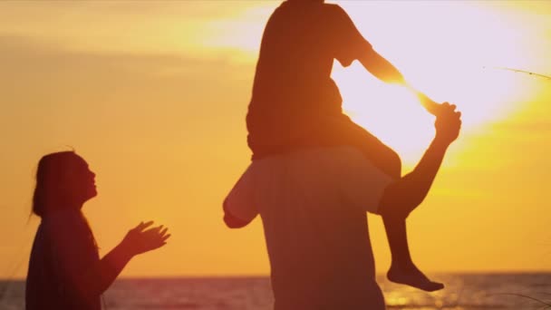 Familie op strand kijken naar zonsondergang — Stockvideo