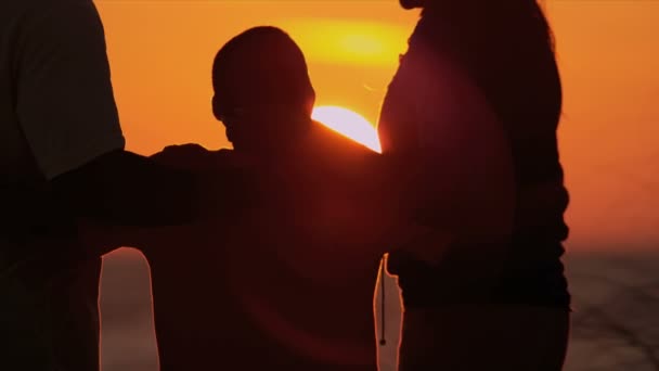 Parents avec fils regardant coucher de soleil — Video