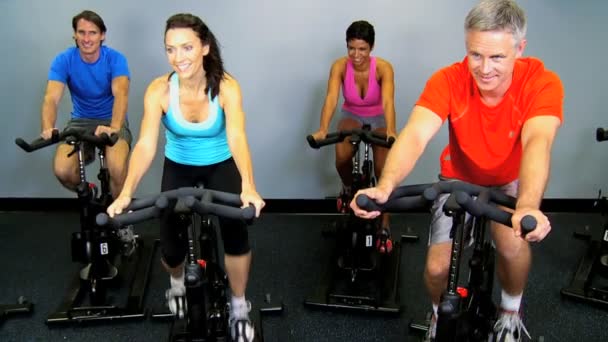 Membros do ginásio em bicicletas de exercício — Vídeo de Stock