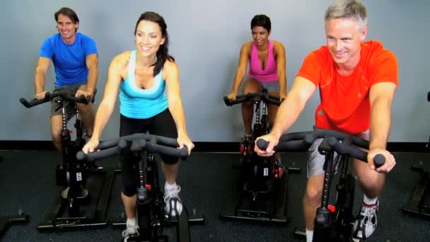 Miembros del gimnasio en bicicletas estáticas — Vídeos de Stock