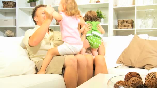 Meninas brincando com os pais no sofá — Vídeo de Stock