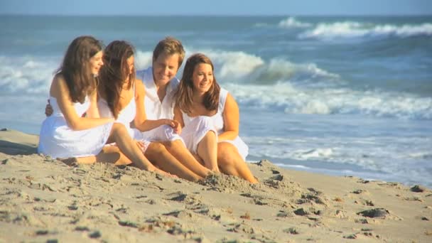 Ευτυχισμένη οικογένεια καυκάσιος που κάθεται έξω στην παραλία — Αρχείο Βίντεο
