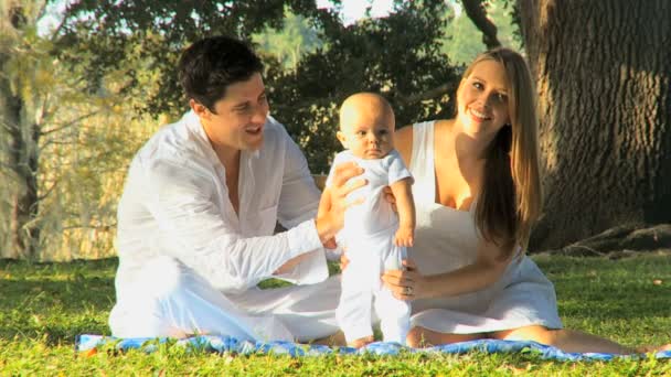 Young couple playing with baby in the park — Stock Video