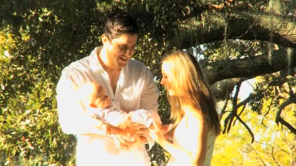 Young couple playing with baby in the park — Stock Video