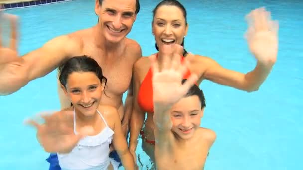 Familia agitando sus manos en la piscina — Vídeo de stock