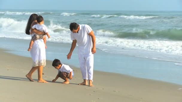 Joven familia hispana jugando a la playa de arena — Vídeo de stock