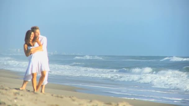 Feliz pareja caucásica vestido blanco disfrutando de la playa — Vídeos de Stock